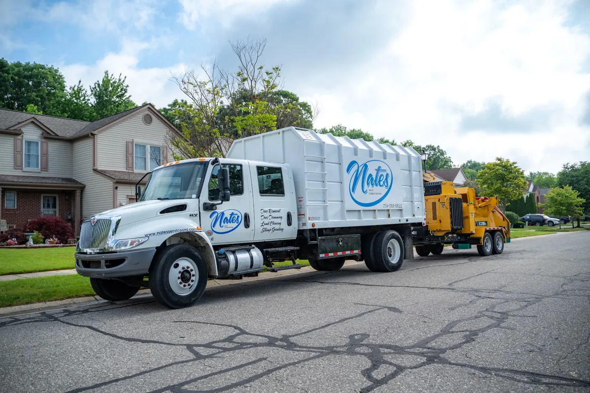 Nate's Tree & Outdoor Services truck and wood chipper on a Southeast Michigan street