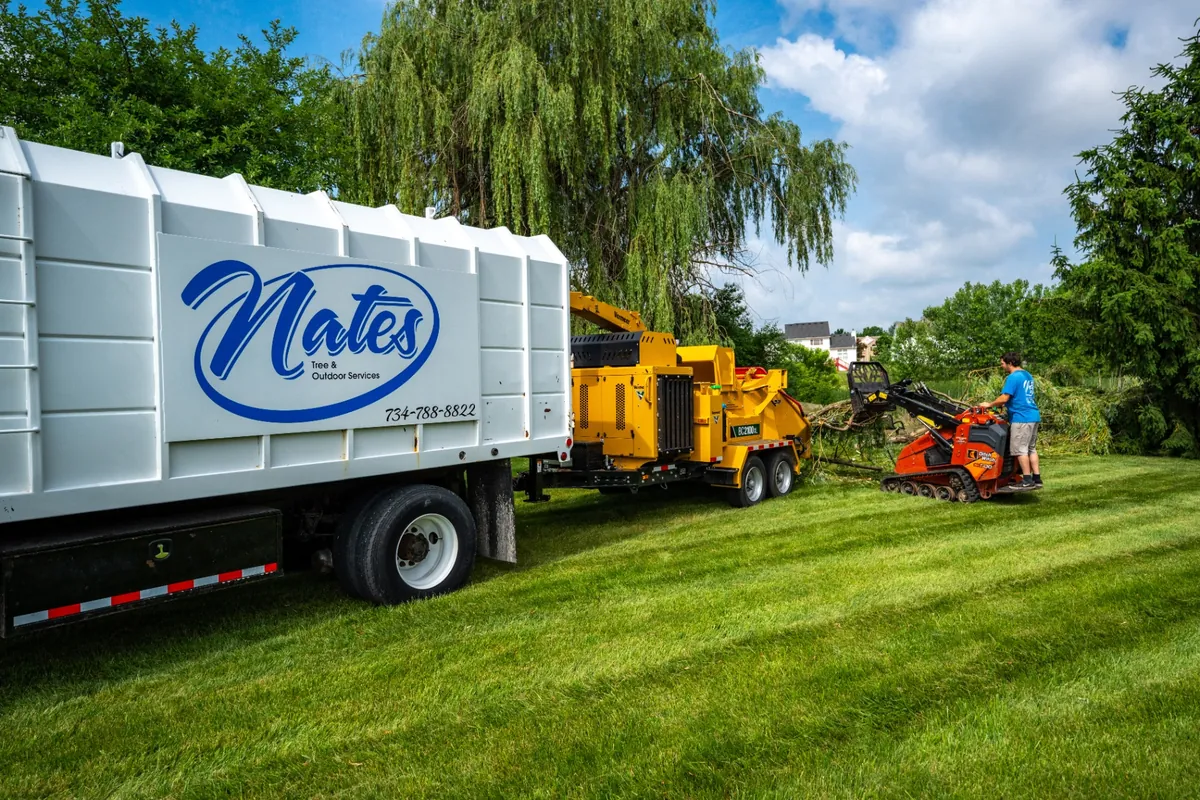 Nate's Tree & Outdoor Services chip truck and wood chipper on the job