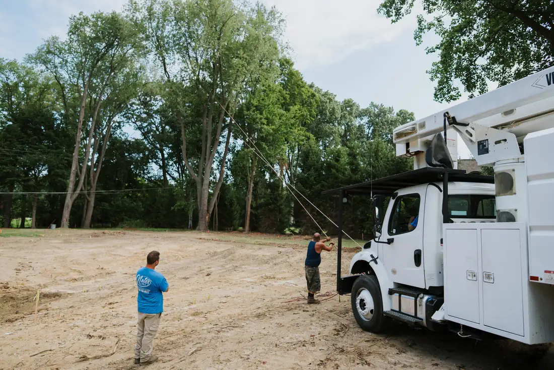 Bucket truck positioned for tree trimming on a residential property in Livonia, MI